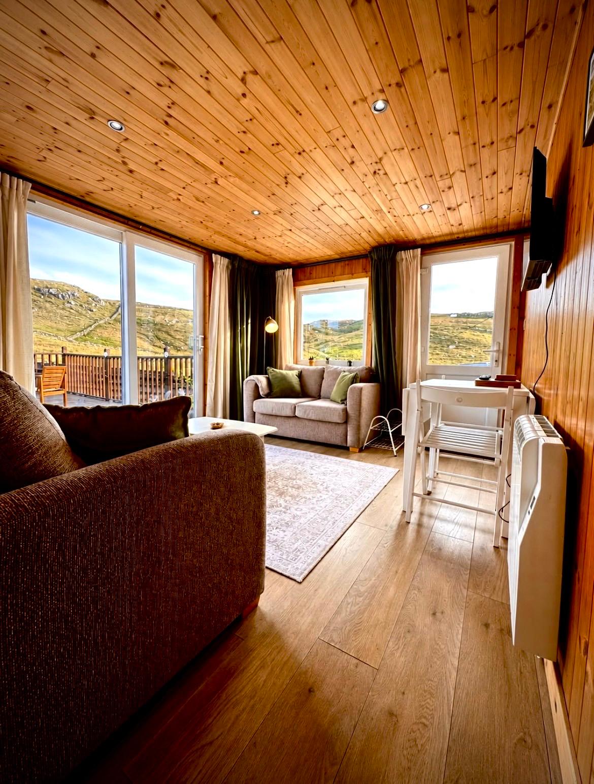 An Tearmann living room with sofas and Highland views through the windows